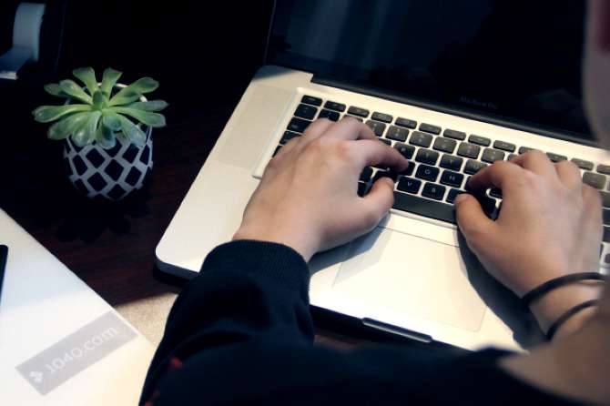 A woman researches tax brackets at her desk.