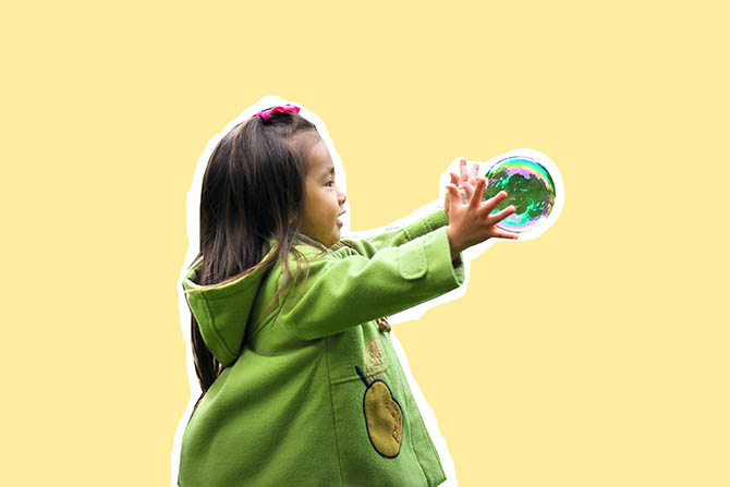 A little girl playing with a bubble