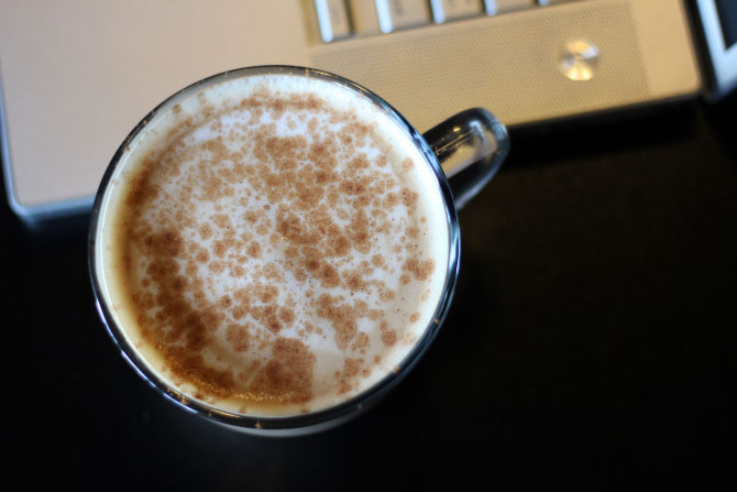 A coffee with cinnamon sits by a laptop for e-filing taxes.