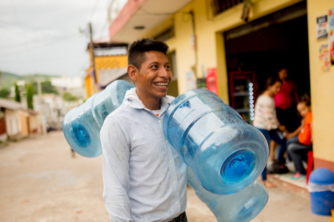 A water store worker loading up with 5-gallon jugs for delivery