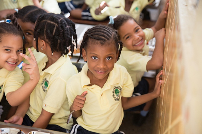 A preschool student smiling in her classroom