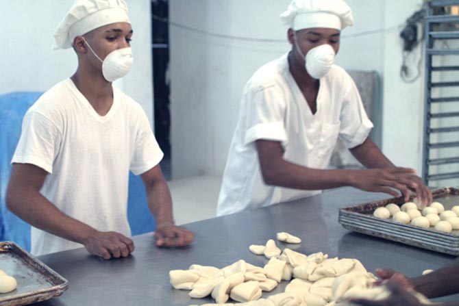 Two men in the Dominican Republic making pastries in a water-funded bakery
