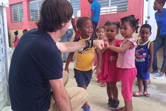 VP James Stork gives fist bumps to children in the Dominican Republic.