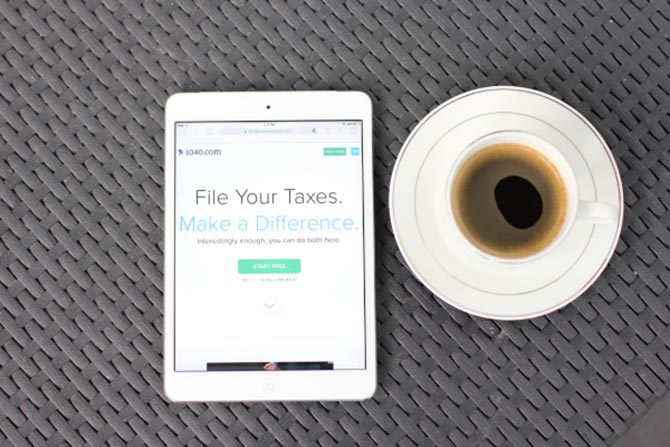 A tablet next to a cup of coffee, so you can file your taxes