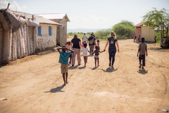 The 1040.com team walking with children through the village of Lubin, Haiti