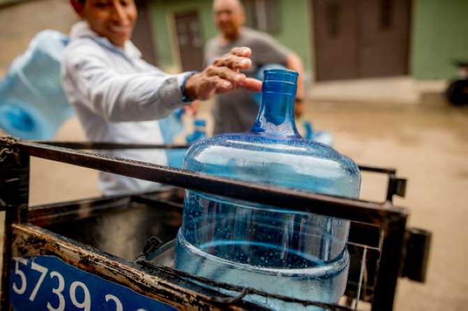 A Healing Waters International motorcyclist packs up water jugs to deliver to his community in Guatemala.