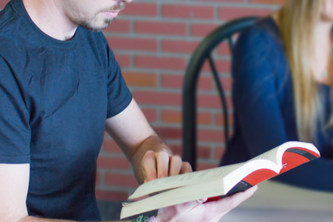 A pastor studying his Bible with a prayer group