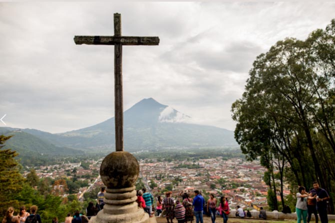 A cross overlooking a volcano in Antigua, Guatemala