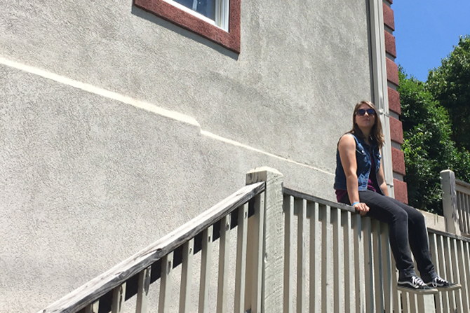 A woman thinking about her financial fitness while sitting in the sunshine