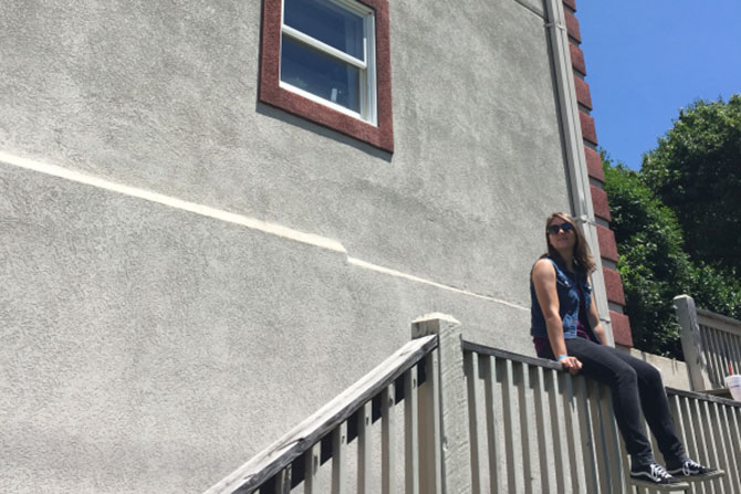 College student sitting on a railing, enjoying the weather on campus.