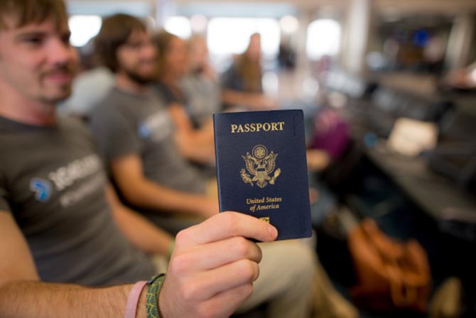 A 1040.com employee holding a passport at an airport