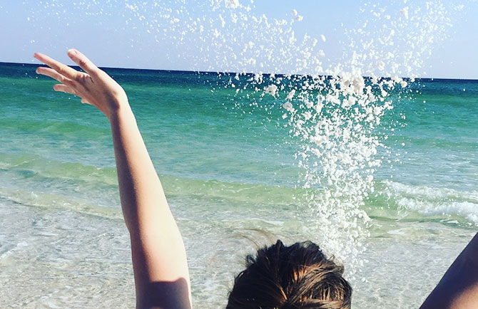 A young woman celebrates her savings with a trip to the beach