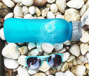 A blue feather water bottle and sunglasses,  props for sunshine and fitness