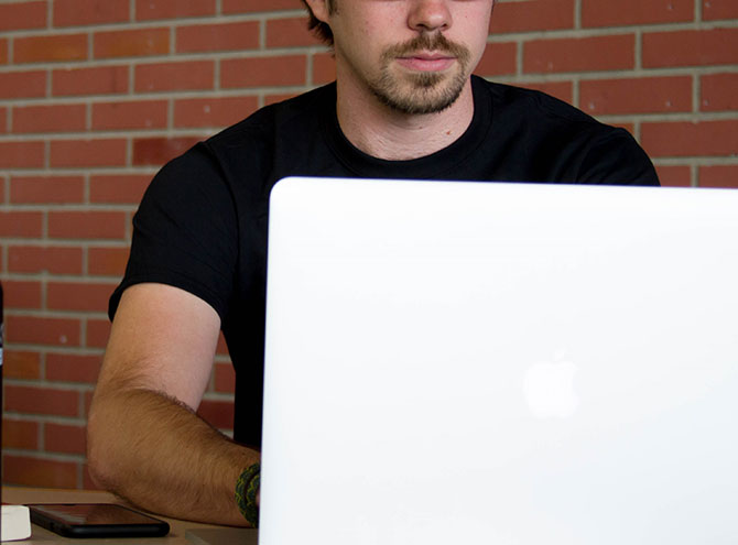 A man working on a computer at a coffee shop.