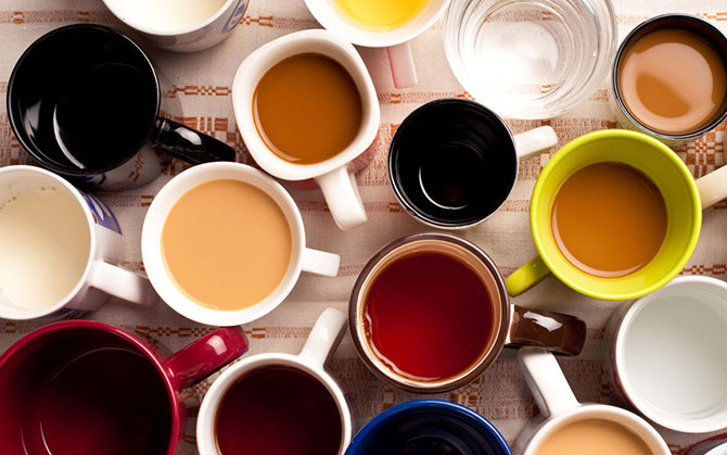 Mugs and hot drinks on an embroidered tablecloth..