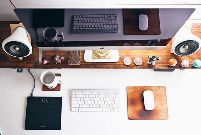 A desk space  prepped for tax filing with coffee, notebooks and figurines