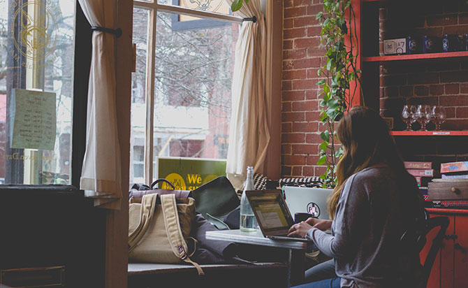  A woman files her taxes in the window of a coffee shop.