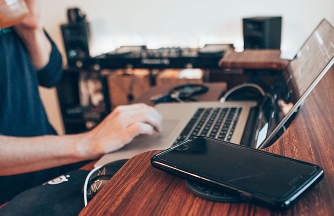 A freelancer checks for jobs on a laptop in a café.