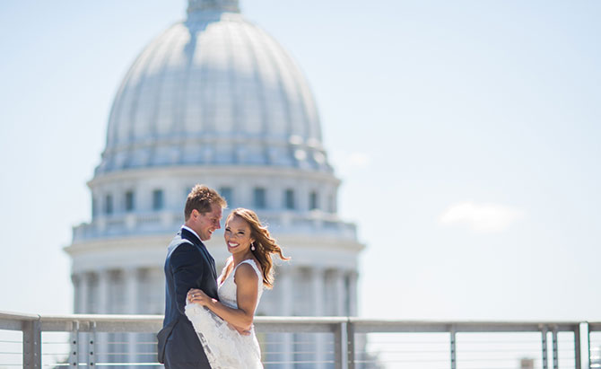 A newly married couple laughing in front of the Capitol Building.