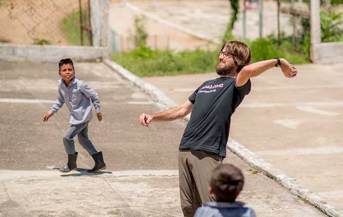 A 1040.com employee plays ball with Guatemalan children.