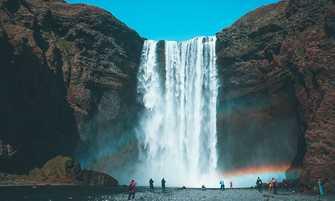 Tourists surrounding a waterfall in Iceland