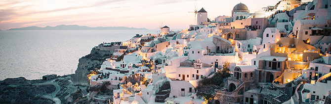 Santorini’s white houses cascading down to the sea at sunset