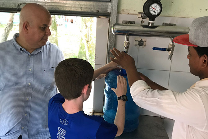 HWI staff show James Stork’s son how the filtration system cleans water.