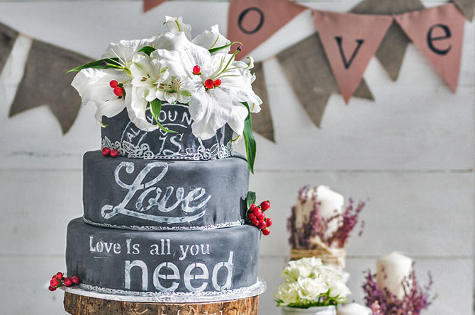 Chalkboard-styled lettering and pastel mason jars complement a vintage wedding cake